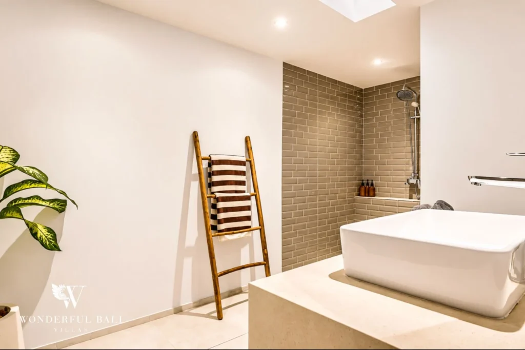 En-suite bathroom with freestanding bathtub and rain shower at villa in Umalas, Bali