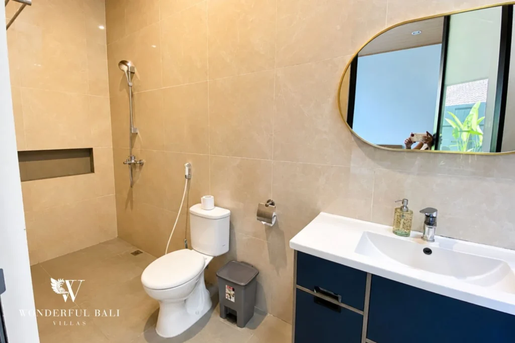 Bathroom with beige tiling and walk-in shower at villa in Canggu, Bali