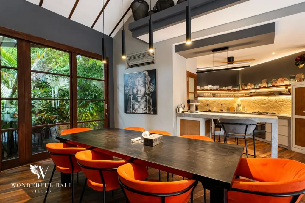 Dining and kitchen with orange chairs and breakfast bar at villa in Umalas, Bali
