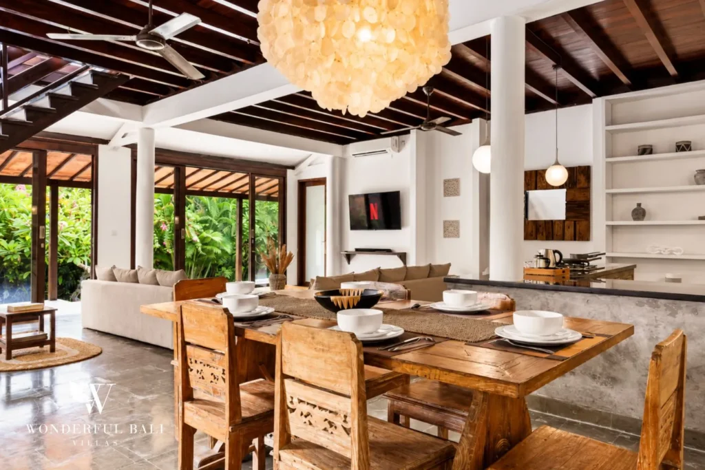 Dining table with rattan pendant open to the garden at villa in Umalas, Bali