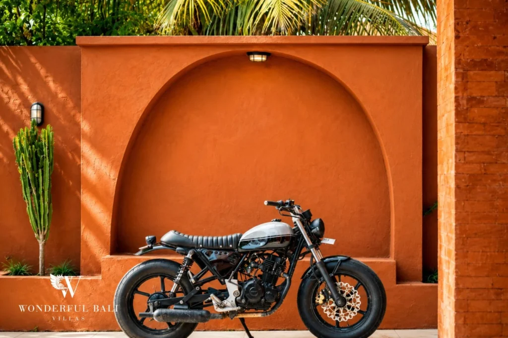 Styled exterior with cafe-racer motorbike against terracotta arch in Nyanyi, Bali