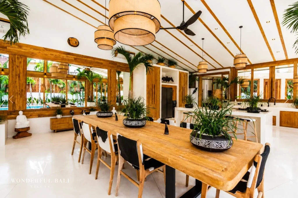 Wooden dining table with rattan pendant lights at family villa in Umalas, Bali