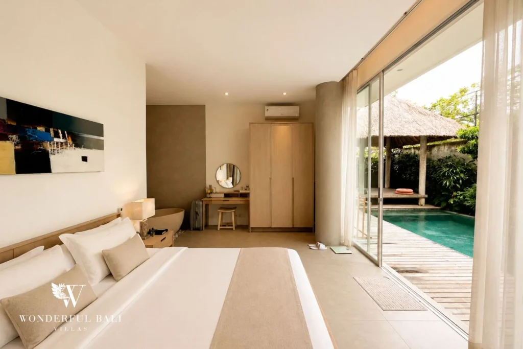 Bedroom with king bed and sliding doors opening to the pool at villa in Petitenget, Bali