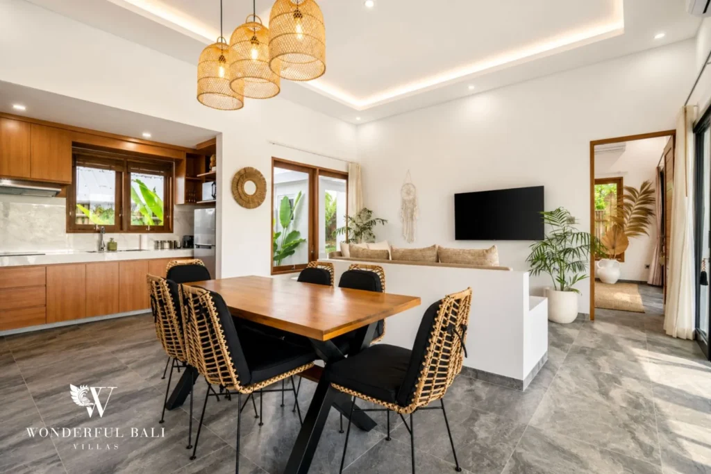 Dining table with woven decor and open kitchen at villa in Ubud, Bali