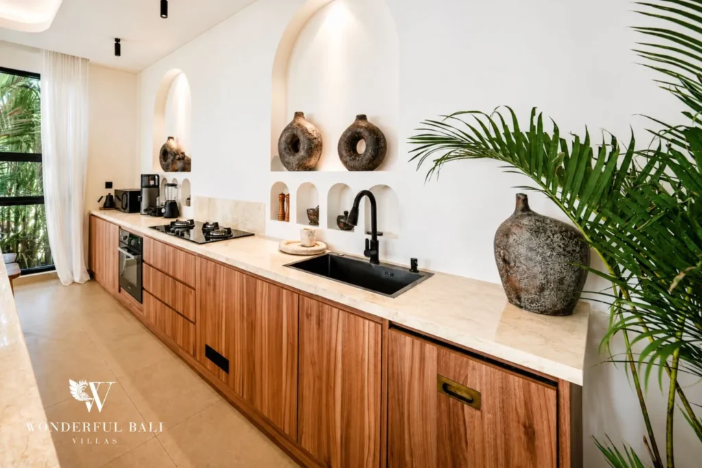 Kitchen with timber cabinets and potted plants at villa in Umalas, Bali