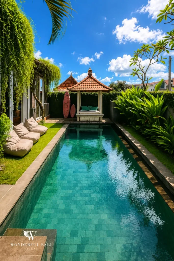Lap pool with sun loungers enclosed by a lush tropical garden at villa in Canggu, Bali