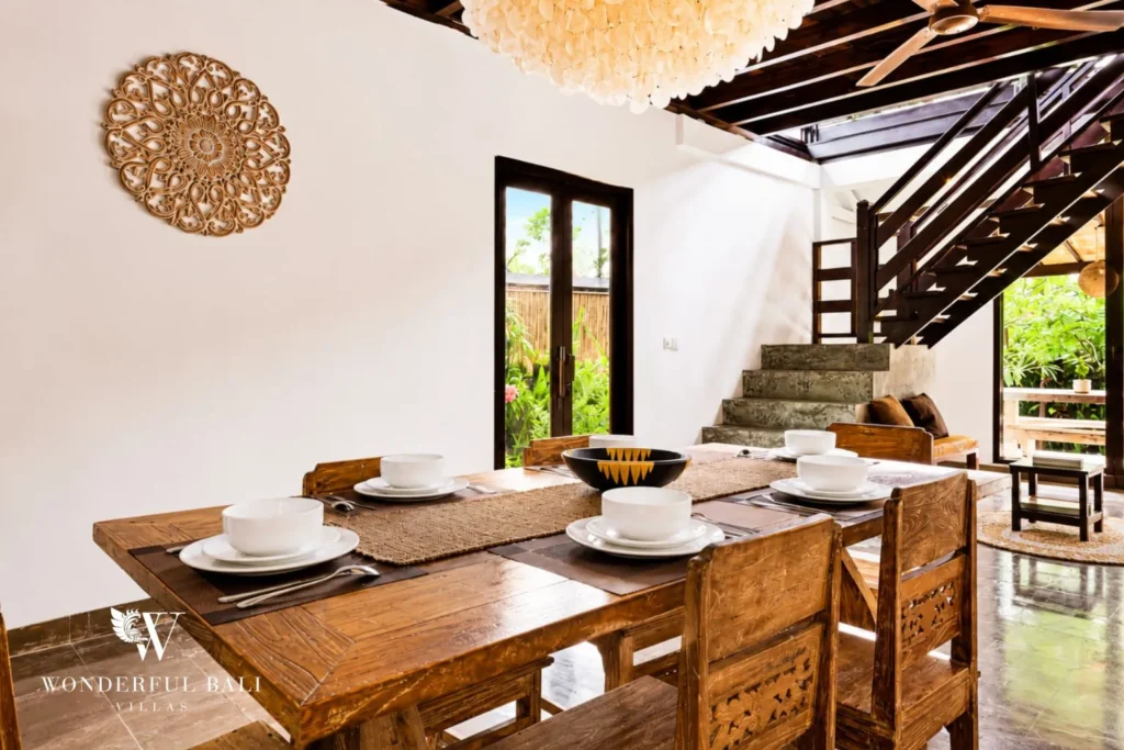 Open-air dining table with garden view and timber ceiling at villa in Umalas, Bali