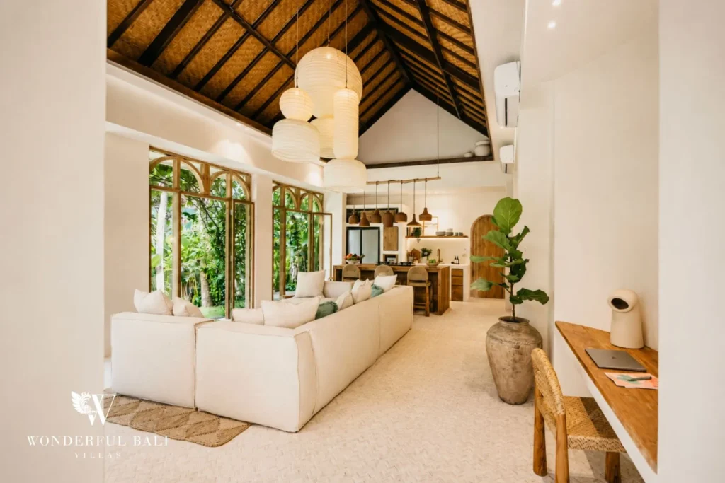 Open living area with high ceiling and glass walls to the garden at villa in Berawa, Bali