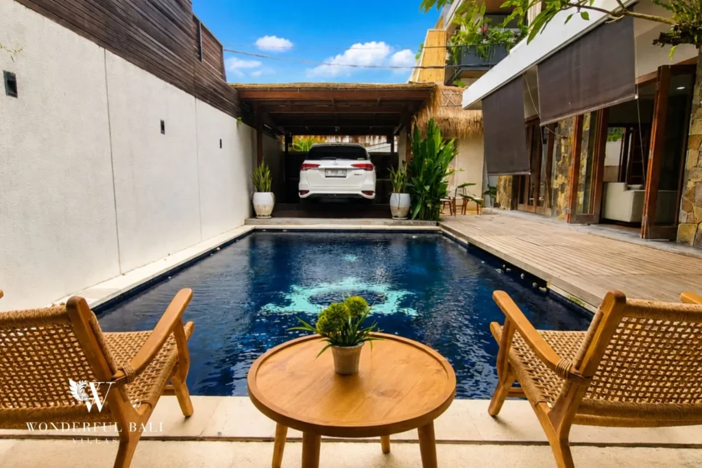 Pool courtyard with round dining table on timber decking at villa in Berawa, Bali