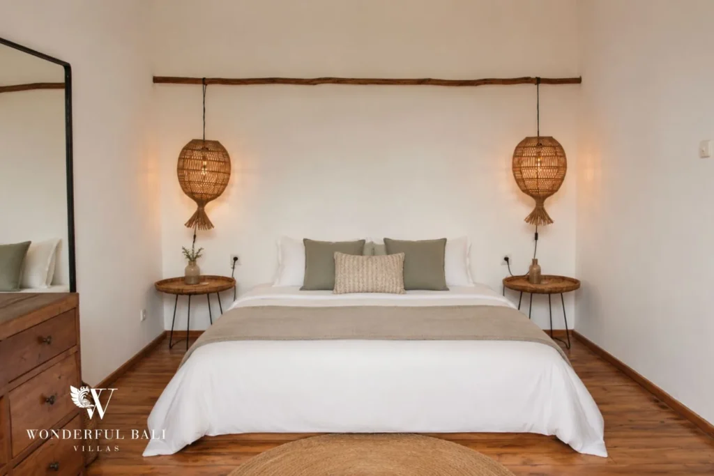 Bedroom with white bed and rattan pendant bedside lamps at villa in Canggu, Bali
