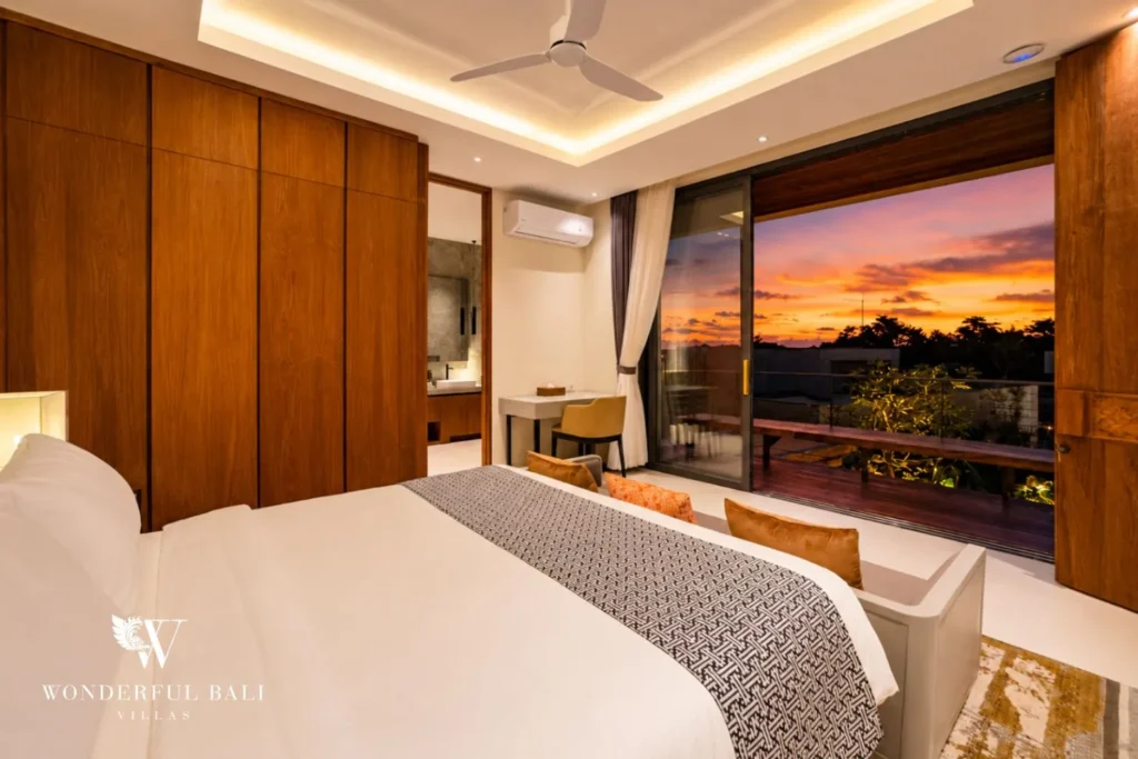 Bedroom with timber wall and sunset view through glass at villa in Umalas, Bali