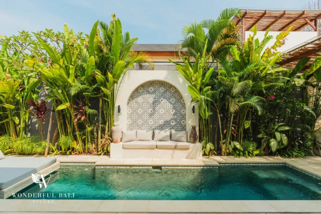 Pool with garden and terracotta wall at villa in Seseh, Bali