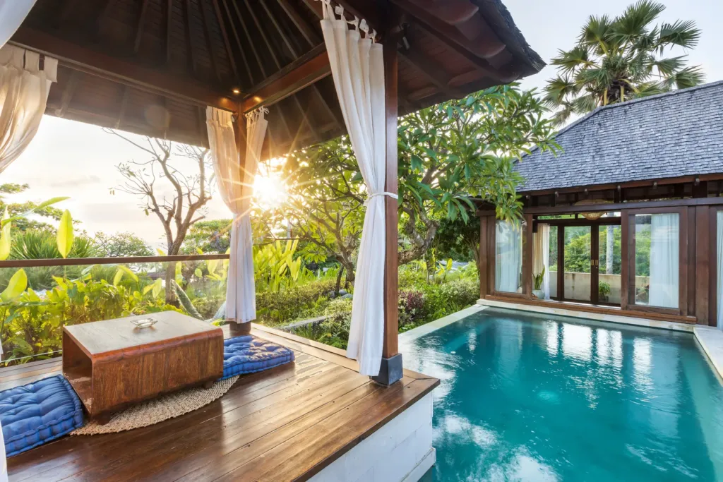 Pool and bale glowing at sunset at villa in Batu Belig, Bali