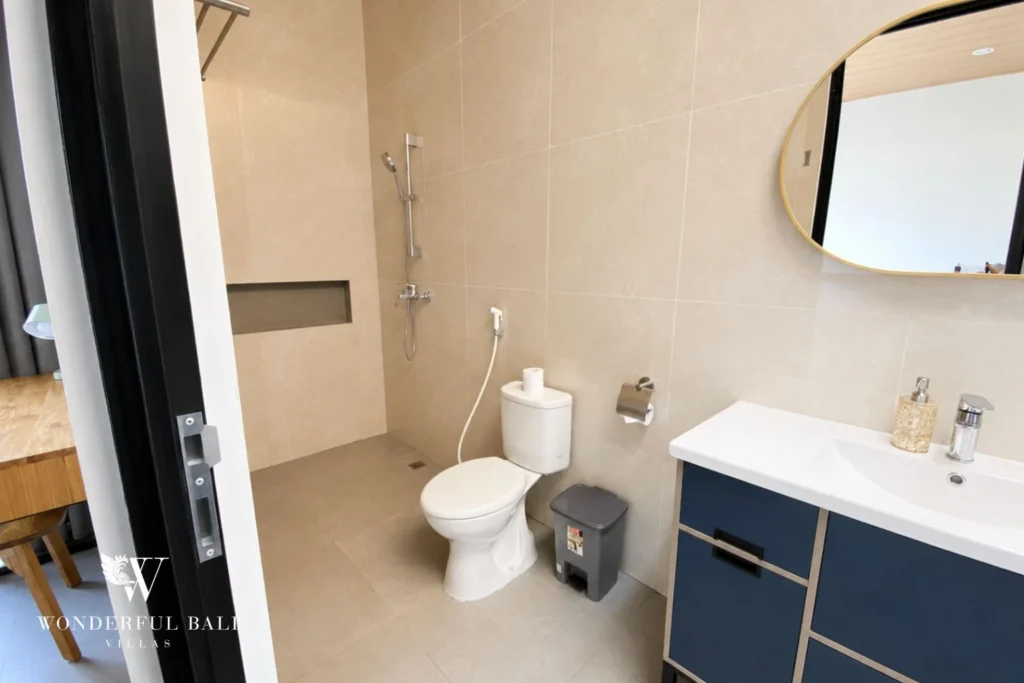 Bathroom with navy vanity and vessel basin at villa in Canggu, Bali