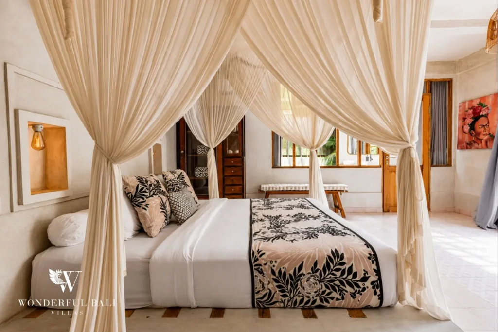 Bedroom with four-poster canopy bed and white drapes at a villa in Canggu, Bali