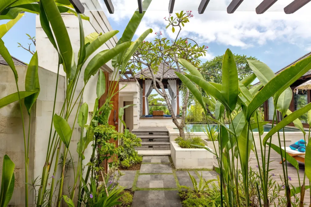 Tropical garden pathway with dense planting at villa in Batu Belig, Bali