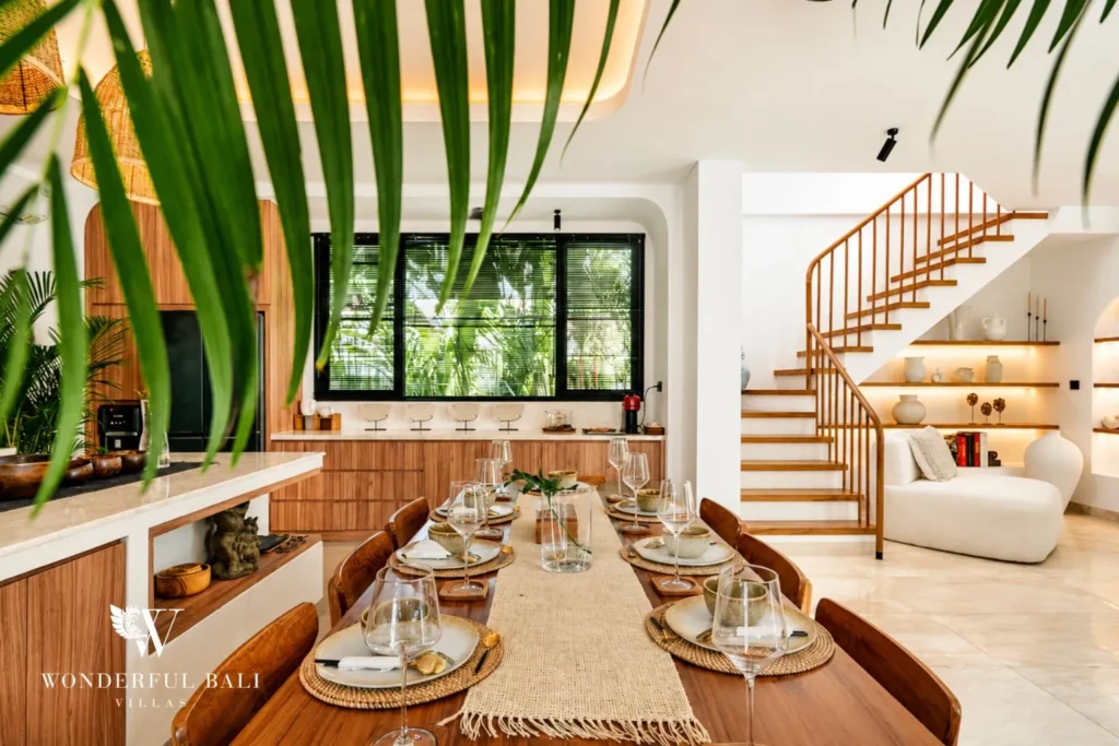 Living area with curved sofa beside a sculptural staircase at villa in Umalas, Bali
