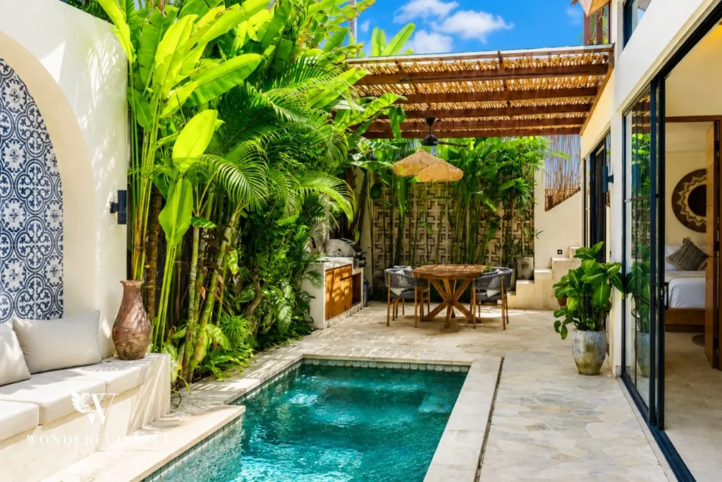 Plunge pool enclosed by lush plants and white walls at villa in Seseh, Bali