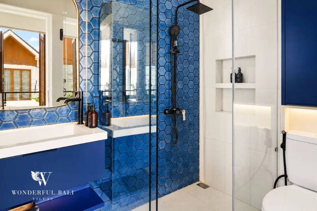 Bathroom with blue tiling, vanity and walk-in shower at villa in Denpasar, Bali