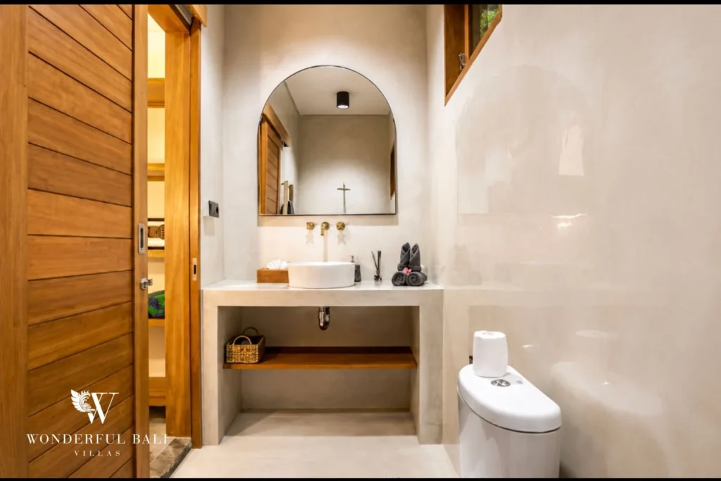 En-suite bathroom with vanity and arched niche at villa in Ubud, Bali