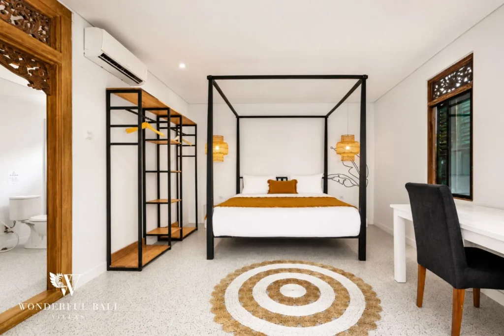 Bedroom with black four-poster bed, wardrobe and desk at villa in Canggu, Bali