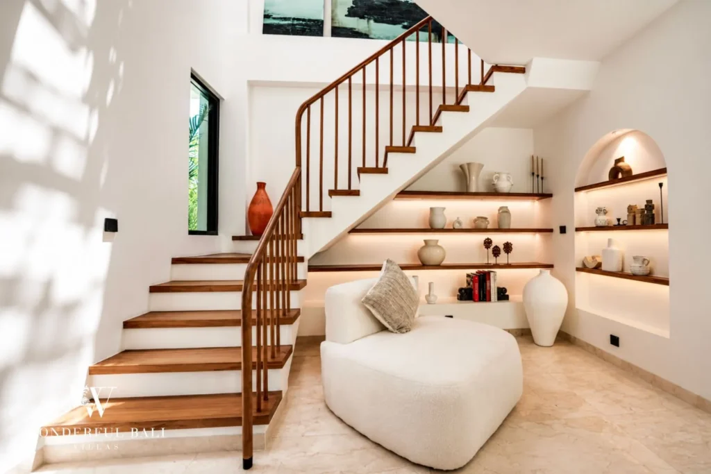 Bedroom with curved bed and arched detailing at villa in Umalas, Bali