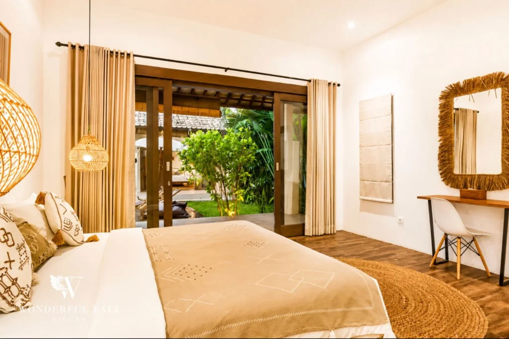 Bedroom with woven pendant light and garden view at villa in Umalas, Bali