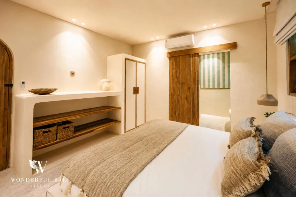 Bedroom in neutral tones with ensuite bathtub at villa in Berawa, Bali