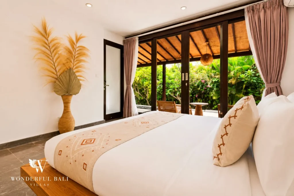 Bedroom with white bed, pampas decor and curtained window at villa in Umalas, Bali