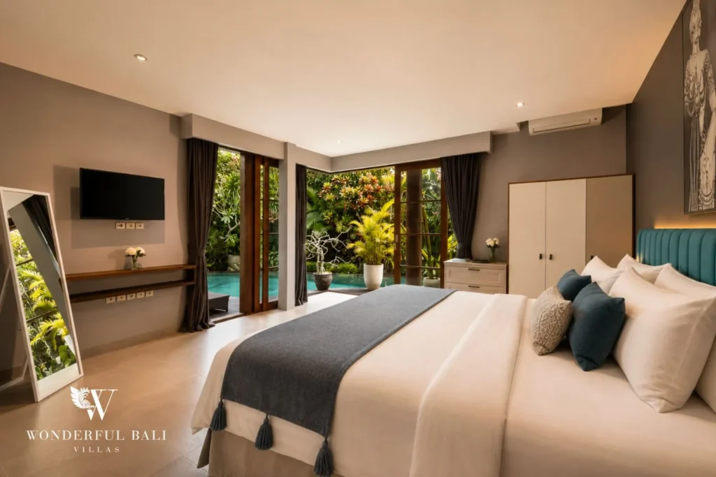 Bedroom with white bed, wall TV and garden view at villa in Umalas, Bali