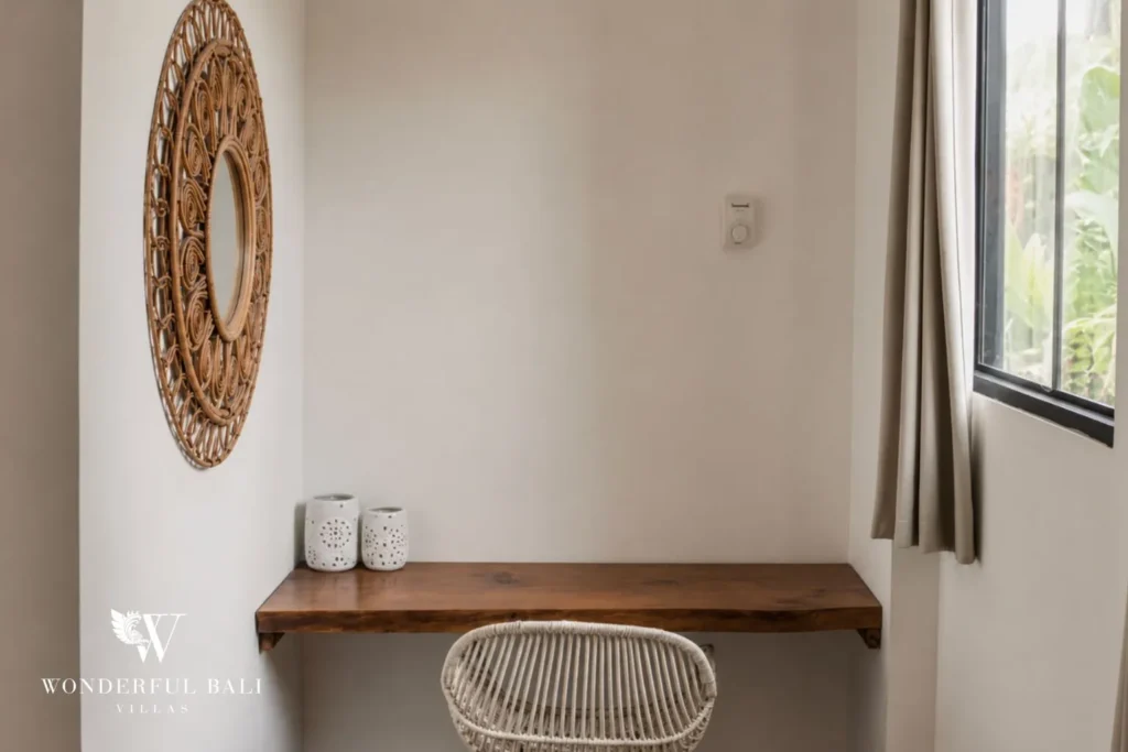 Console vanity with round woven mirror and rattan stool at villa in Canggu, Bali