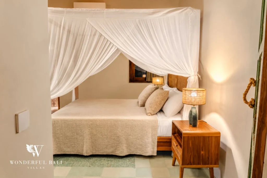 Bedroom with four-poster bed and mosquito net at villa in Bumbak, Bali