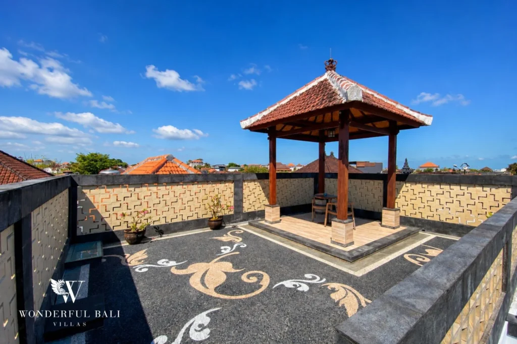 Rooftop Balinese pendopo gazebo with carved timber pillars at villa in Canggu, Bali
