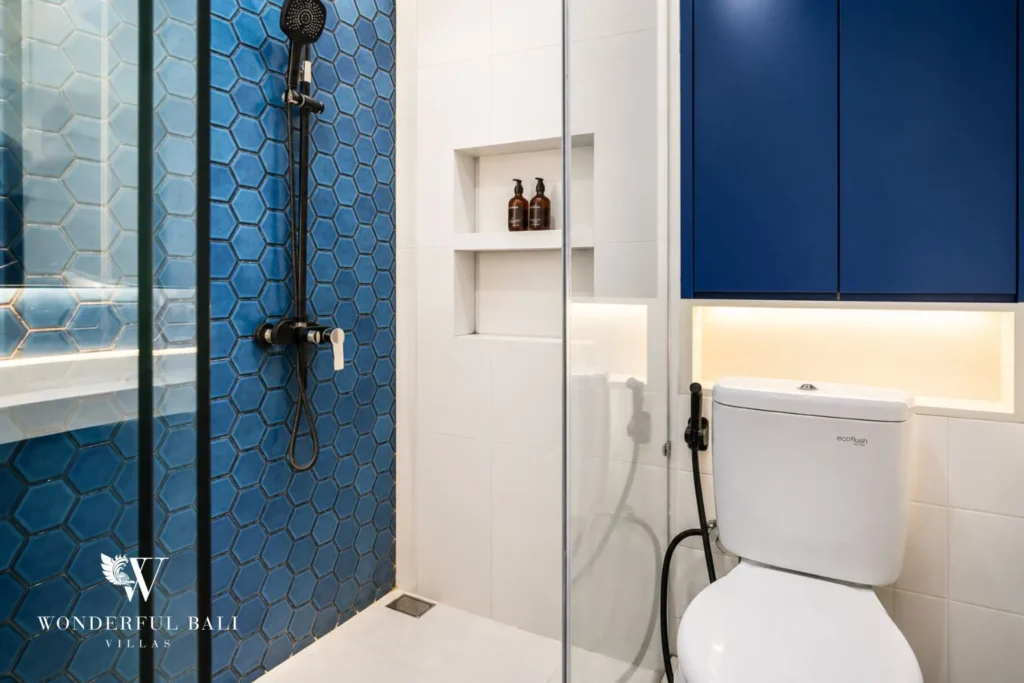Bedroom with blue wall and balcony doors to an open view at villa in Denpasar, Bali