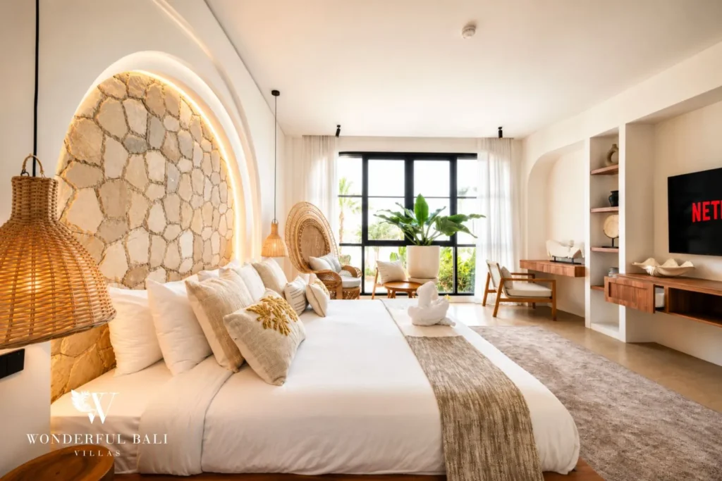 Bedroom in neutral tones with TV niche and plant at villa in Umalas, Bali