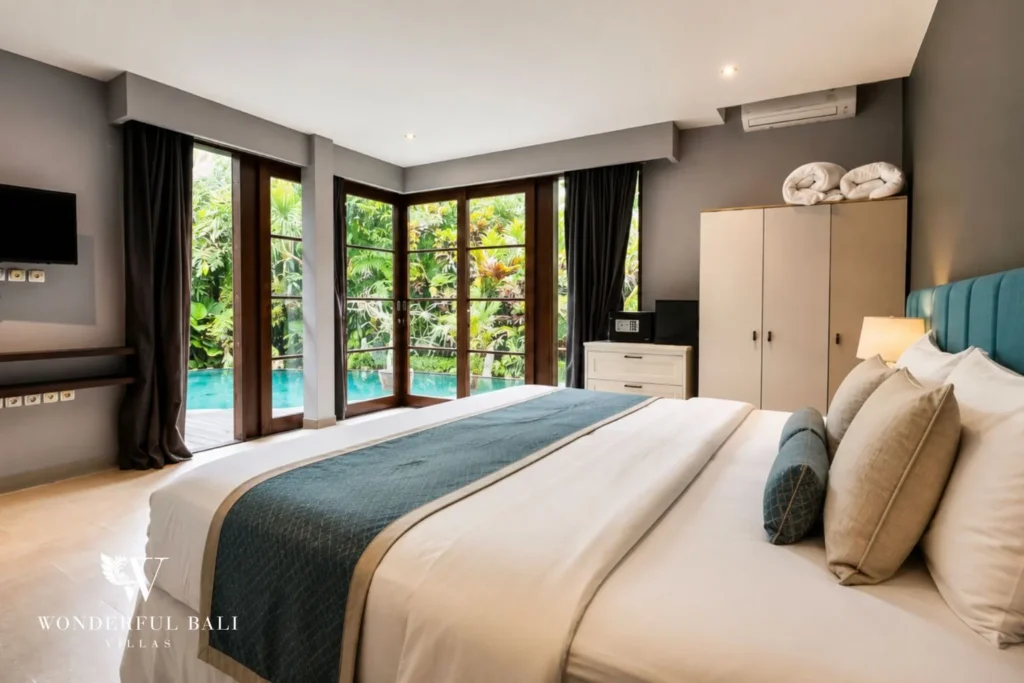 Bedroom with teal throw and glass doors to the pool garden at villa in Umalas, Bali