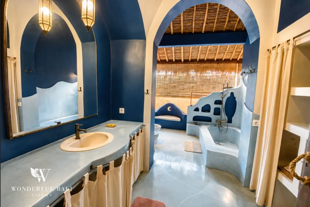 Blue Moroccan-style bathroom with arches and vessel basin at villa in Bumbak, Bali