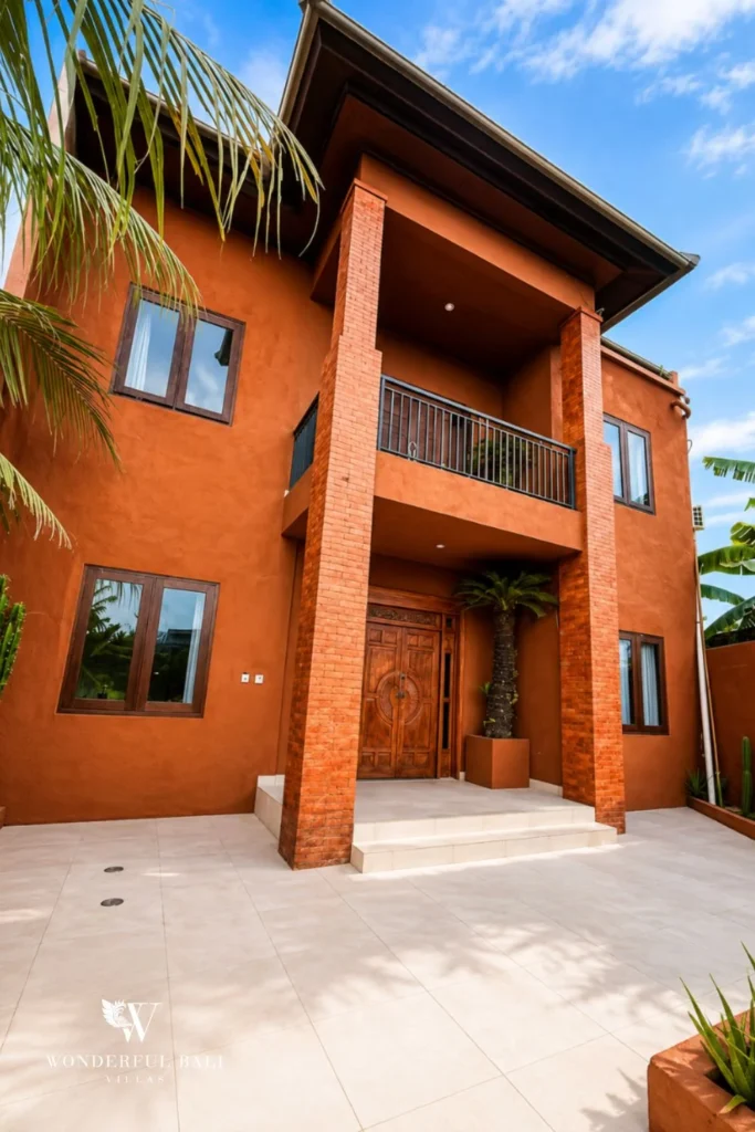 Two-storey terracotta villa with balcony and traditional door in Nyanyi, Bali