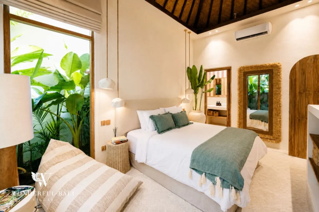 Bedroom with green-striped wall and tropical plants at villa in Berawa, Bali
