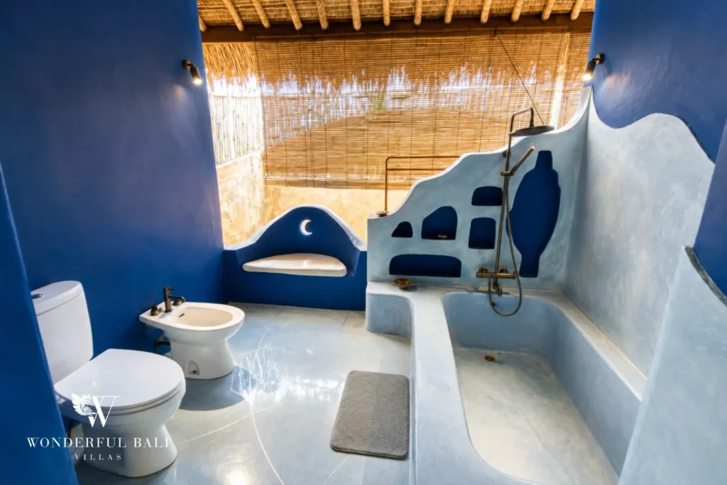 Blue Moroccan-style bathroom with arched niches and vessel basin at villa in Bumbak, Bali
