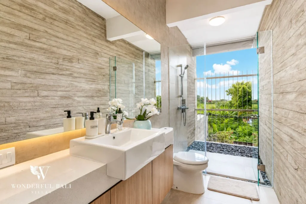 En-suite bathroom with walk-in shower and garden view at villa in Petitenget, Bali