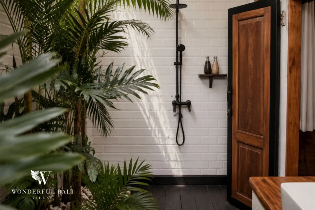 Bathroom with walk-in shower, timber door and plants at villa in Canggu, Bali