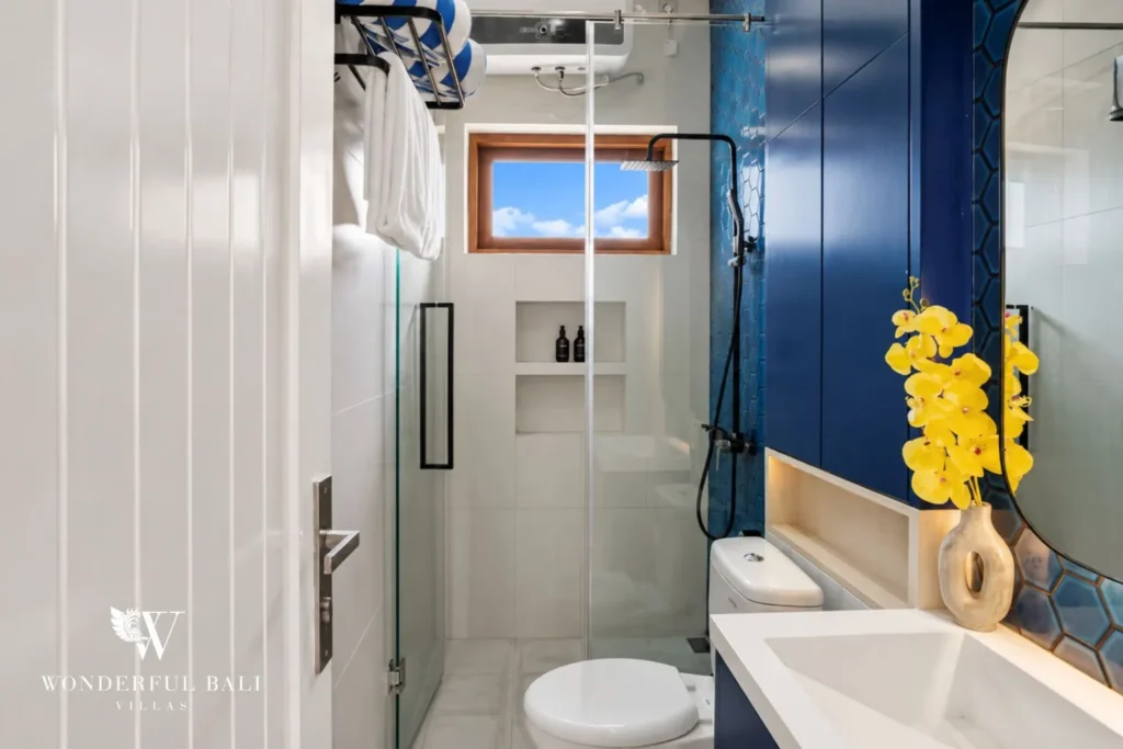 Bathroom with glass walk-in shower and toilet at villa in Denpasar, Bali