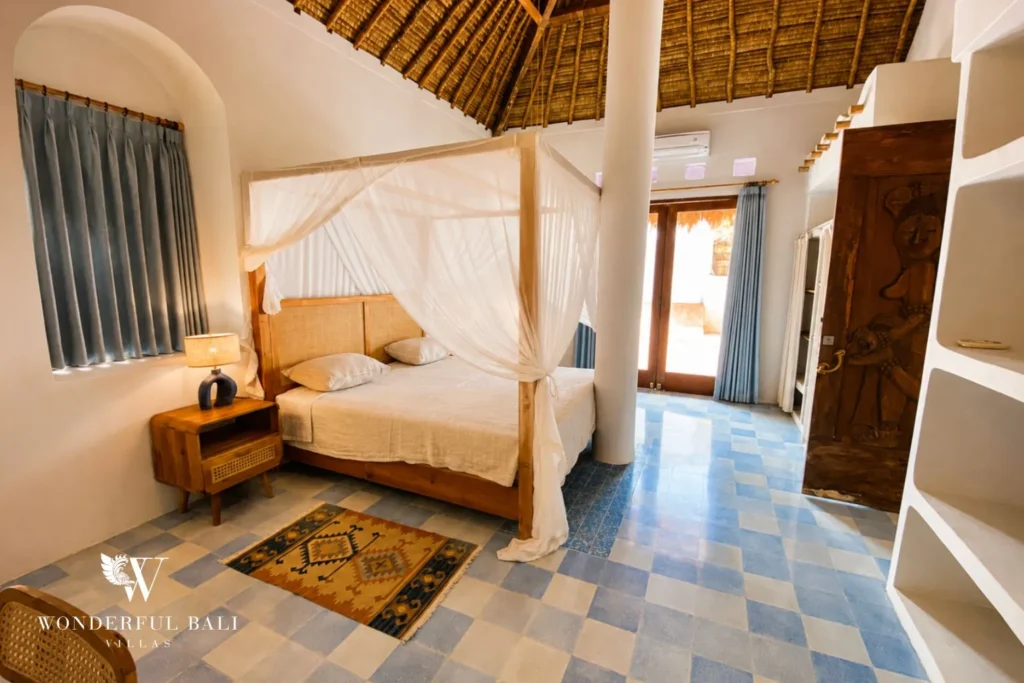 Bedroom with canopy bed and checkered floor on a loft level at villa in Bumbak, Bali