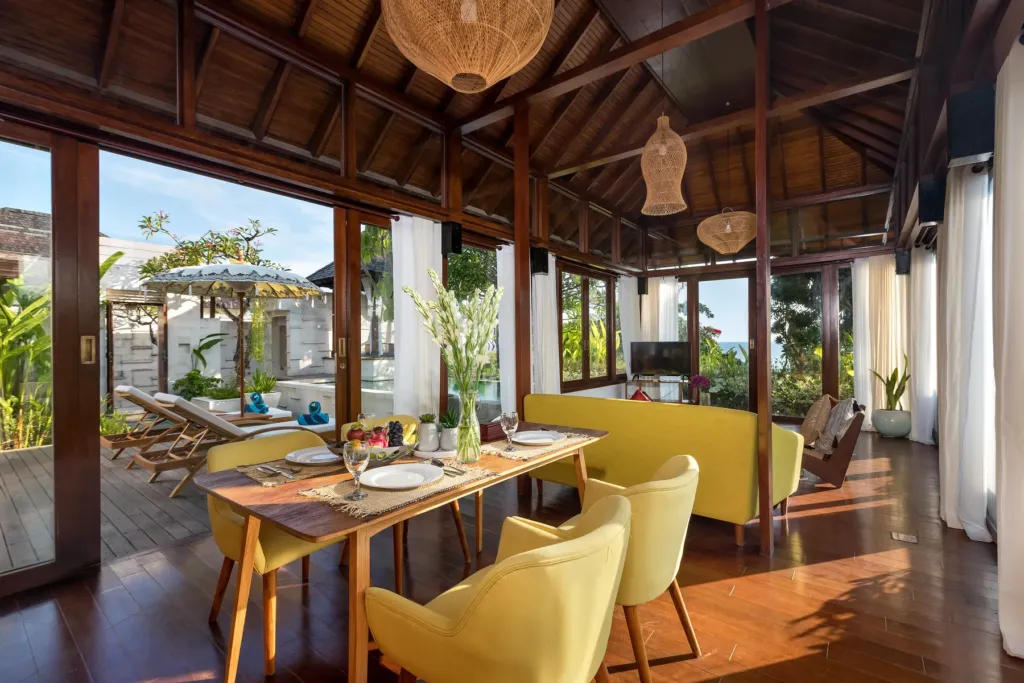 Dining area with timber table and yellow chairs at villa in Batu Belig, Bali