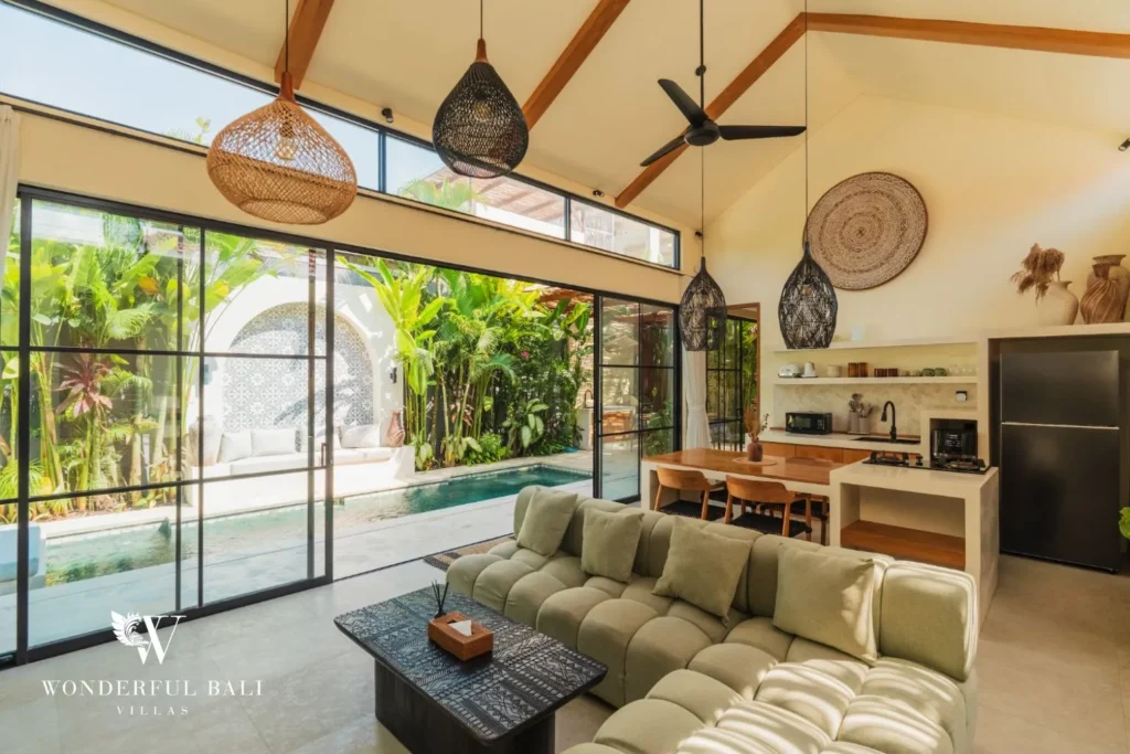 Living area with sofa under a timber ceiling and glass doors at villa in Seseh, Bali