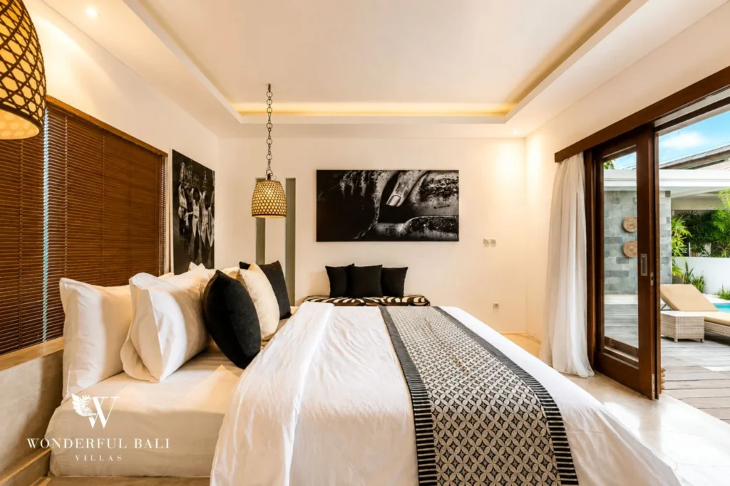 Master bedroom with Buddha artworks and pool-facing glass doors at villa in Seminyak, Bali