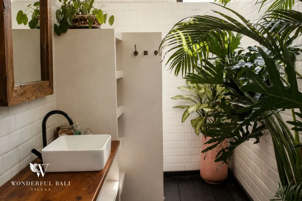 Bathroom with black basin vanity, mirror and plants at villa in Canggu, Bali