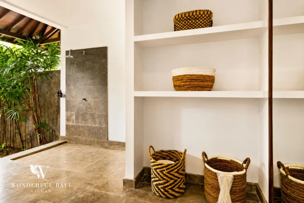 Bathroom with stone niche shelving and woven baskets at villa in Umalas, Bali