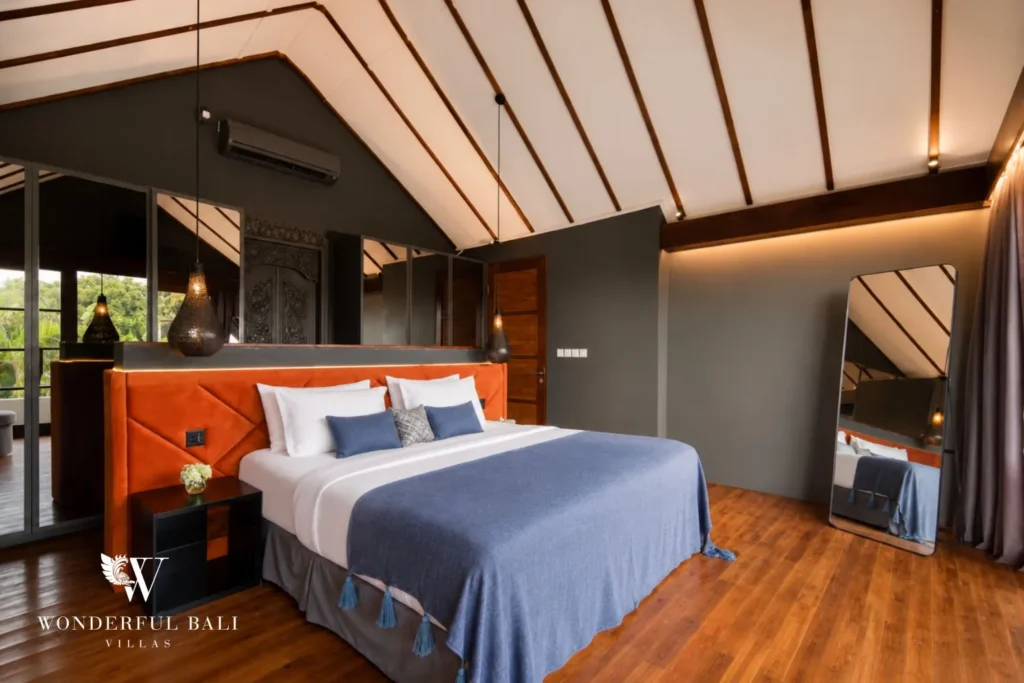 Bedroom with orange headboard under a pitched timber ceiling at villa in Umalas, Bali